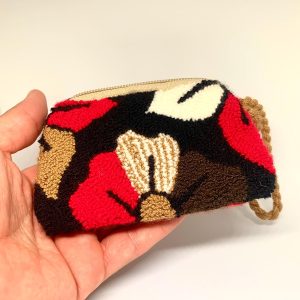 Monedero colorido Wayuu de embrague. Fondo negro con flores